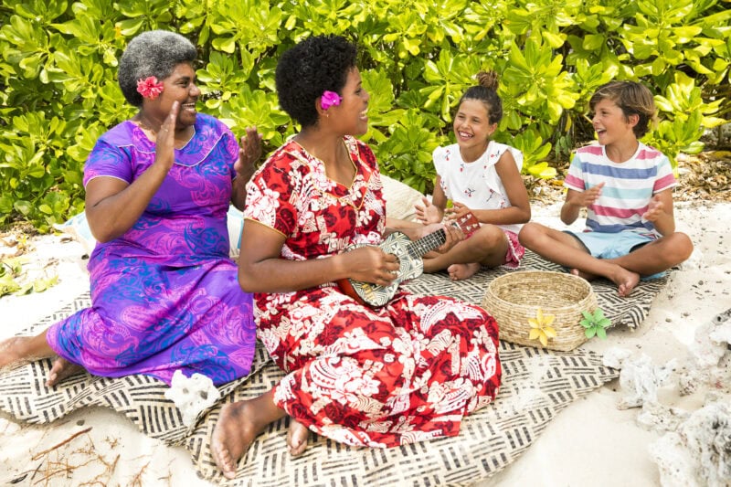 Nannies &amp; Kids singing on a woven mat.