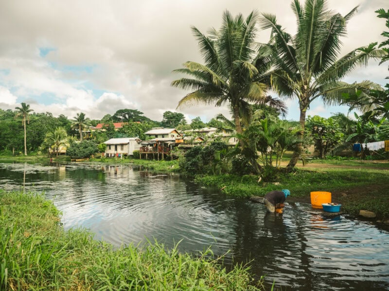 Village scene of clothes being washed in a creek near a Fijian village - a common sight in rural areas.